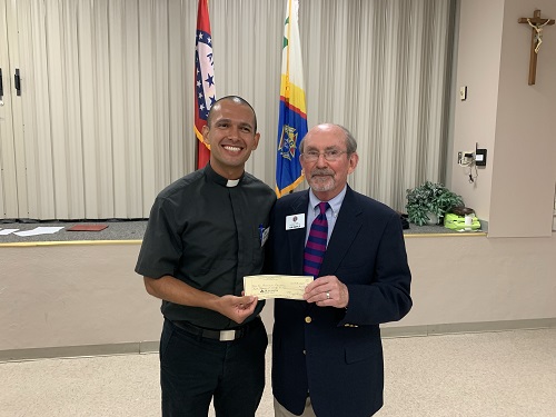 Father Mauricio receiving check from GK Ed Doyle